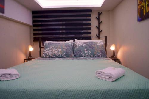 a bedroom with a bed with two towels on it at Στούντιο στο κέντρο της πόλης. in Volos