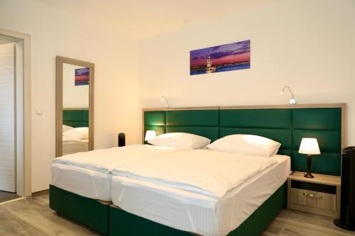 um quarto com uma cama grande e uma cabeceira verde em W2 Ferienwohnung-32609 Hüllhorst em Hüllhorst