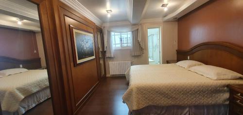 a hotel room with two beds and a window at Cobertura na Borges de Medeiros - ( 3 quadras rua coberta ) in Gramado