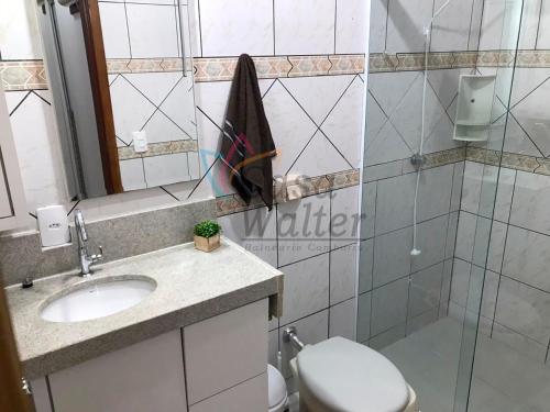 a bathroom with a toilet and a sink and a mirror at Casa Walter in Balneário Camboriú