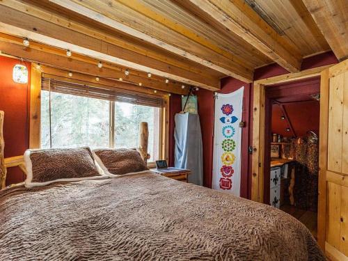 Cama grande en habitación con ventana en Treehouse On The Stream Sundance, Utah, en Sundance