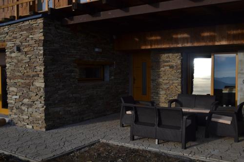 a patio with chairs and a table in front of a building at Luxury Wellness Apartment in Rokytnice nad Jizerou