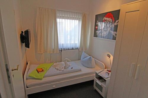 a small room with a bed and a window at Kapitaenshaus-Lassen-Zimmer-Kajuete in Westerland