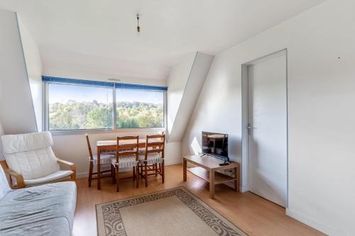 un salon avec une table et des chaises et une fenêtre dans l'établissement Appartement Vallon - Welkeys, à Houlgate