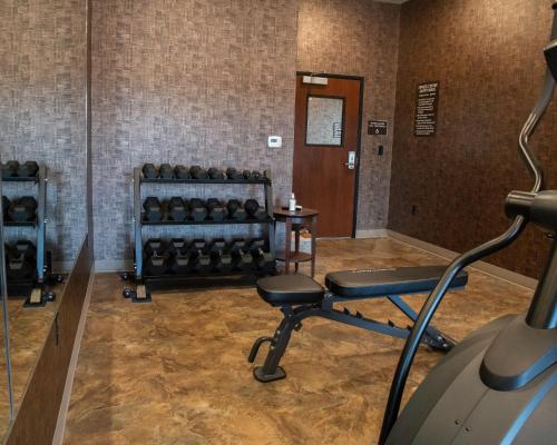 a room with a gym with a bench and weights at Cobblestone Hotel & Suites - Two Rivers in Two Rivers