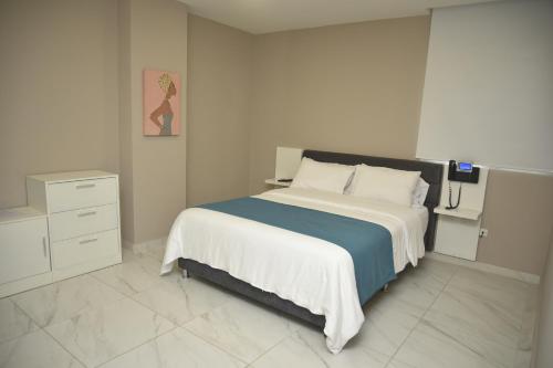 a bedroom with a bed with a blue and white blanket at OR HOTEL 94 in Barranquilla