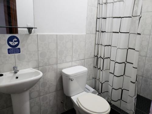 uma casa de banho com um WC branco e um lavatório. em Shale Hotel em Chachapoyas