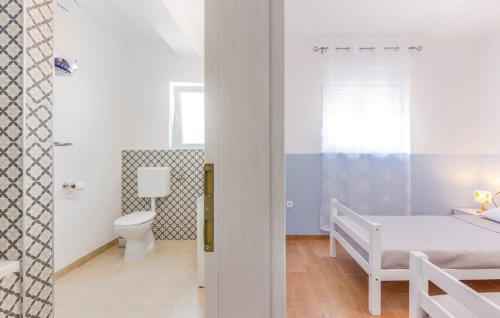 a white bedroom with a bed and a toilet at Holiday Home Aqua in Šmrika