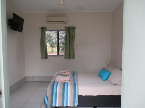a small room with a bed and a window at Ingham Tourist Park in Ingham