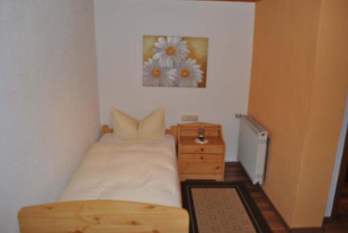 a small bedroom with a bed and a table at Zur Alten Dampfsäge - Gasthaus-Pension Weber in Lindberg