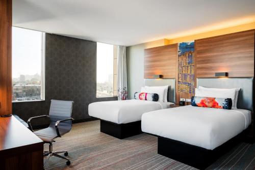 a hotel room with two beds and a desk at Sky Loft Hotel Kyiv by Rixwell International in Kyiv