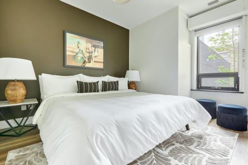 Un dormitorio con una gran cama blanca y una ventana en Sonder The Elm, en Toronto