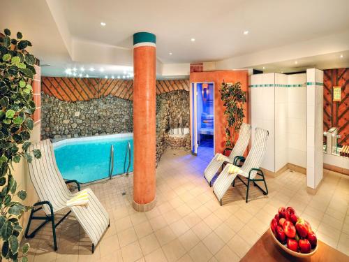 a room with a pool and two chairs and a table at Hotel zum Hirschen Zell am See in Zell am See