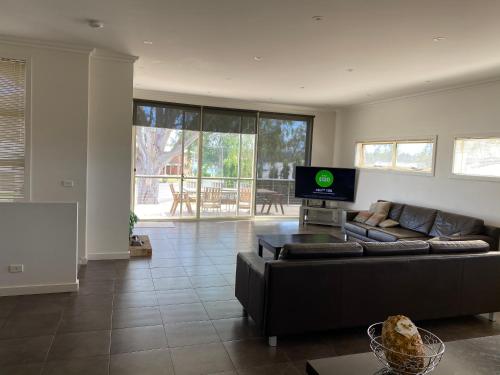 a living room with a couch and a flat screen tv at Bundalong Waterfront in Bundalong