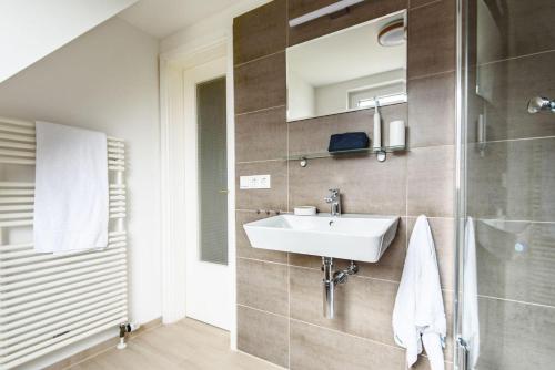 ヘルヌムにあるFerienwohnung-LUVのバスルーム(洗面台、ガラス張りのシャワー付)