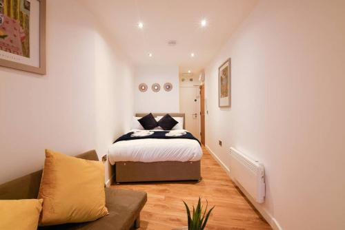a bedroom with a bed and a couch at Long Row Apartments in Nottingham City Centre in Nottingham