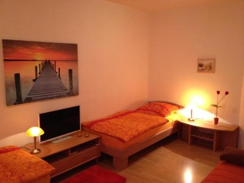 ライプツィヒにあるModerne-Ferienwohnung-in-ruhiger-zentraler-Lage-am-Parkのベッド1台とテレビが備わる小さな客室です。
