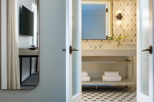 a bathroom with a sink and a mirror at Kimpton Cottonwood Hotel, an IHG Hotel in Omaha