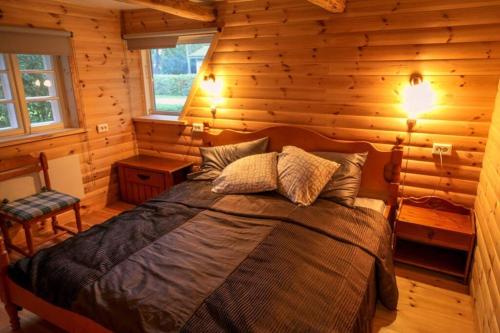 1 dormitorio con 1 cama en una cabaña de madera en Baltic Getaway en Käina