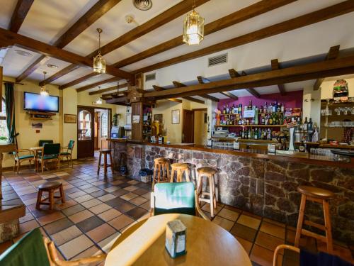 a bar in a restaurant with wooden tables and chairs at Tierra de la Reina in Boca de Huérgano