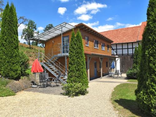 a large wooden house with a staircase in front of it at holiday home Kellerwald Edersee National Park in Bad Wildungen