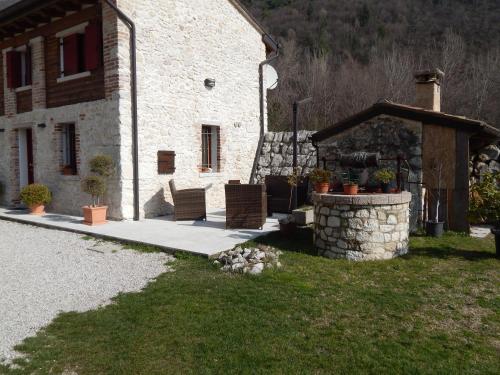 a stone building with a table and chairs in front of it at Monte Grappa Guest House in Romano D'Ezzelino