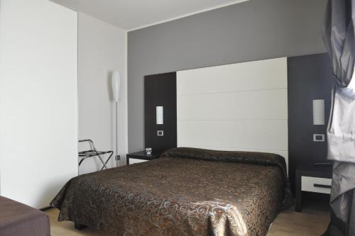 1 dormitorio con cama y pared blanca en Casa Boffa en Barbaresco