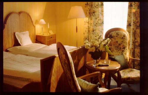 um quarto de hotel com uma cama, uma mesa e cadeiras em Unser kleines Hotel Café Göbel em Laubach