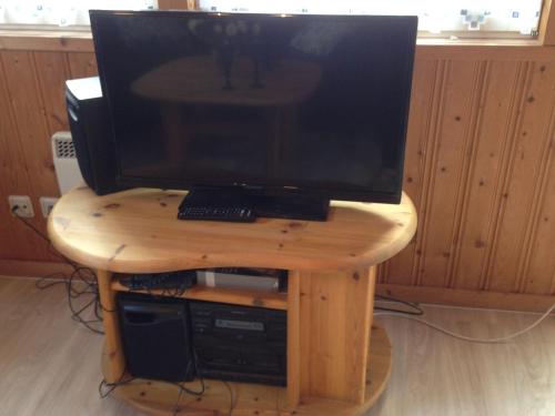 TV sobre una mesa de madera en Villa-Bunterkunt-am-Useriner-See, en Userin