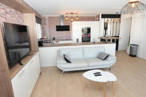 un salon avec un canapé et une cuisine dans l'établissement Rouen Vue Cathédrale, à Rouen