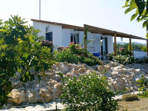 a house with a pile of rocks in front of a house at Charming Holiday Home in Kritinia with Garden in Kritinía