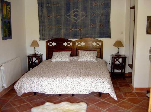 a bedroom with a bed and two tables with lamps at Holiday Home Finca Retama in Ronda
