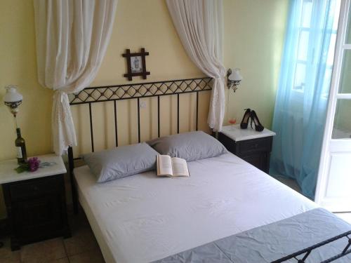 a bedroom with a bed with two books on it at Aelia by Eltheon in Imerovigli