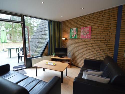 StramproyにあるLovely Holiday Home in Limburg amid Lush Forestのレンガの壁、黒い家具が備わるリビングルーム
