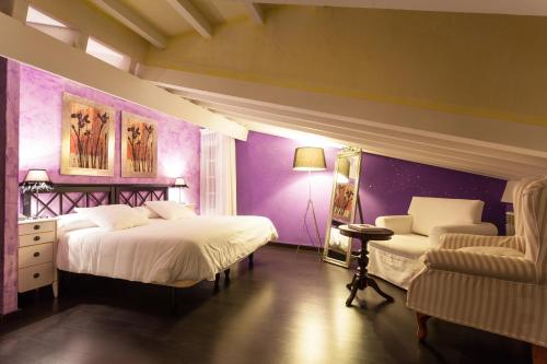 a purple bedroom with two beds and a chair at El Bosque de La Anjana in Selores