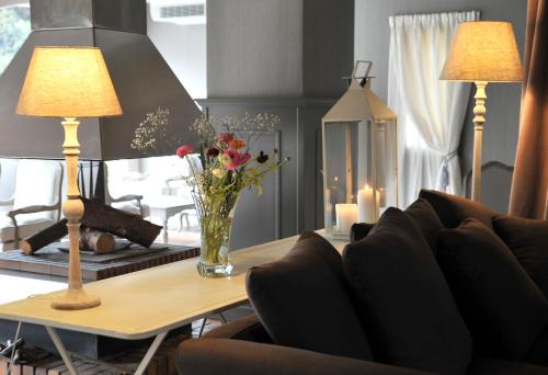 a living room with a table with a vase of flowers at La Lune De Mougins - Hotel & Spa in Mougins