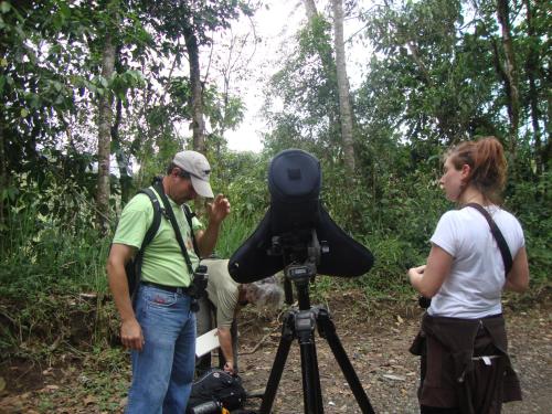 a man and a woman standing in front of a camera at Cabañas Armonía y Jardín de Orquídeas in Mindo