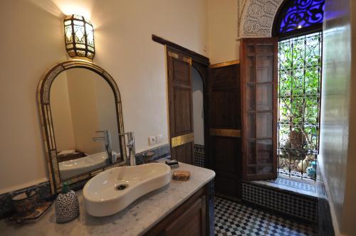 La salle de bains est pourvue d'un lavabo et d'un miroir. dans l'établissement Riad Le Sucrier de Fès, à Fès