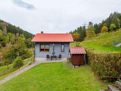 ein kleines Haus auf einem Hügel mit einem Hof in der Unterkunft Holiday home in Thuringia near the lake in Langenbach