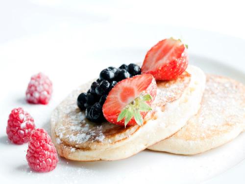 a plate of pancakes with fruit on top at Virginia Court Hotel in Cromer