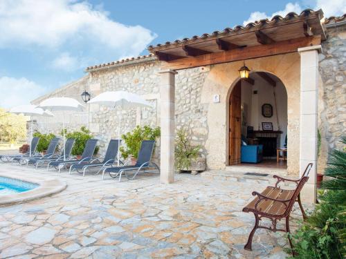 a group of chairs on a patio next to a pool at Belvilla by OYO Villa Campanet Vell in Campanet