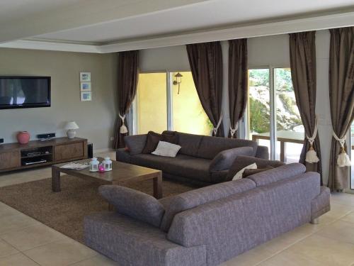 sala de estar con 2 sofás y TV en Opulent Villa in Le muy with Swimming Pool, en Le Muy
