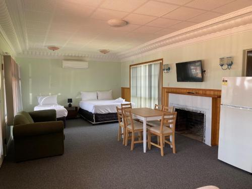 a hotel room with a bed and a table and chairs at Lakeside Motel Waterfront in Lakes Entrance
