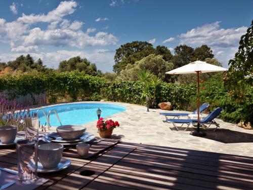 a pool with a table and chairs and an umbrella at Apartment in the historic center -no parking- 100 meters from the lake in Prinés