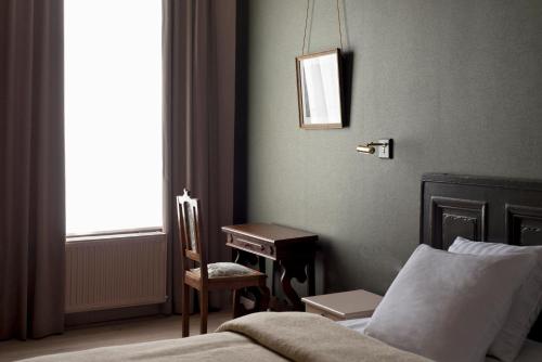 a bedroom with a bed and a table and a chair at Boutique hotel Sint Jacob in Maastricht