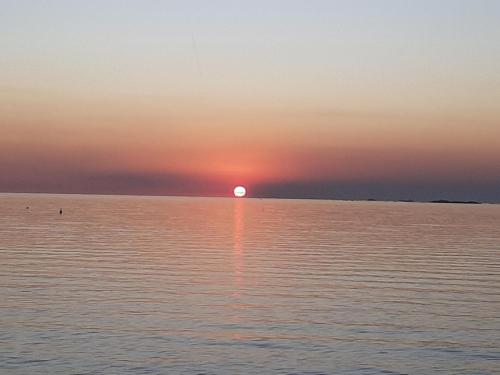 a sunset over the water with the sun setting at Loft del barranco in Colonia del Sacramento