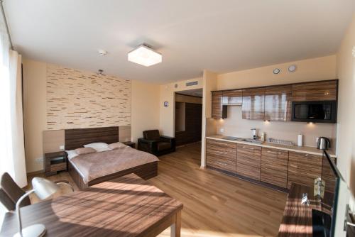 a living room with a bed and a kitchen at Just Apartments in Wrocław