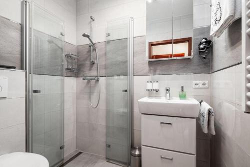 a white bathroom with a shower and a sink at Strand-Park in Travemünde