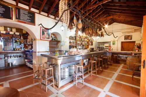 a bar in a restaurant with wooden stools at Hostal El Cortijo in Algodonales