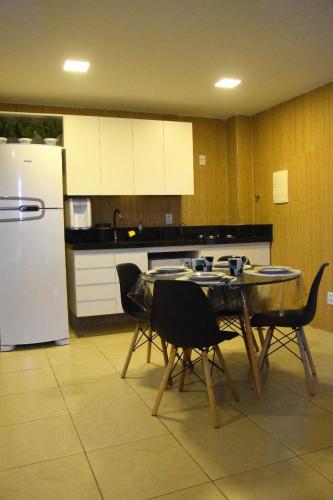 uma cozinha com uma mesa e cadeiras e um frigorífico em Ana marinho flat 702 em Natal